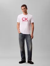 Remera Calvin Klein de manga corta y cuello redondo, color blanco, con estampado gráfico de monograma rojo en el pecho.