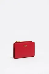 Billetera compacta de cuero vacuno color negro, con cierre superior metálico dorado y logo de la marca estampado en el frente.