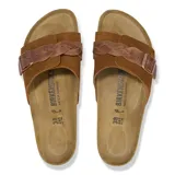 Sandalia tipo slide con plantilla anatómica de corcho y suela de goma. Presenta una banda ancha de gamuza con diseño trenzado y una hebilla metálica ajustable.