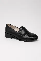 Mocasín clásico de cuero negro, con taco bajo y ancho de 4 cm. Combina laterales lisos con un panel frontal de acabado brillante y textura sutil, con una banda ancha sobre el empeine.