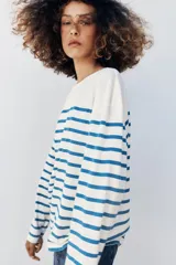 Camiseta de manga larga con diseño a rayas horizontales en color marrón sobre base color crudo, con cuello redondo y corte regular fit.