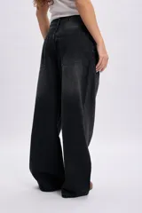 Pantalón jean baggy de corte ancho y tiro alto, en color negro con efecto acid wash.