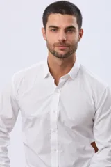 Camisa de vestir blanca entallada, de manga larga, cuello camisero y cierre frontal de botones, con elastano añadido para mayor confort.