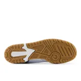 Championes urbanos New Balance modelo 550, color blanco con detalles en gris y suela color caramelo, confeccionados en cuero y gamuza, con logo "N" característico en los laterales.