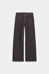 Jeans de tiro medio, color negro lavado con efecto desgastado, corte recto y holgado (loose straight), con cinco bolsillos y cierre frontal de cremallera y botón.