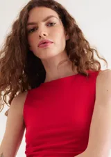 Top rojo sin mangas confeccionado en tejido de punto, con cuello redondo alto y diseño ajustado con detalles de pliegues asimétricos en el lateral.