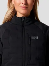 Campera técnica Mountain Hardwear modelo Stretchdown, color negro, con aislamiento de plumón de ganso. Presenta cierre frontal de dos vías, cuello alto, bolsillo en el pecho con cierre y bolsillos laterales. Diseño elástico con costuras selladas para mayor libertad de movimiento.