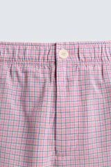 Bermuda de hombre con corte relaxed fit, tiro medio, cintura elástica con botón y cierre de cremallera. Presenta un patrón de cuadros pequeños en tonos rosados y grises.
