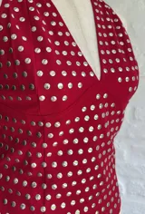 Top halter rojo con escote en V y apliques metálicos plateados.