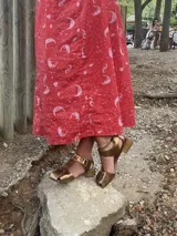 Sandalias de cuero color dorado, con taco cuadrado, diseño de tiras anchas entrelazadas en la parte delantera y tira ajustable con hebilla en el tobillo.