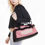 Bolso deportivo Puma Challenger Duffel, color rosado con detalles en negro. Cuenta con compartimento principal con cierre, bolsillo lateral de malla para ventilación y bolsillo lateral con cierre. Incluye asas de mano y correa ajustable para el hombro.