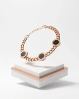 Pulsera de acero color oro rosa con cadena de eslabones y dijes circulares con detalles en negro y números romanos grabados.