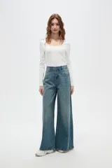 Pantalon de jean estilo wide leg con tiro medio, bolsillos laterales y traseros, y ruedo desflecado.