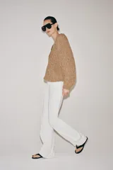 Sweater de punto con cinta entrelazada, color tostado, escote redondo pronunciado y manga larga con puños ajustados.