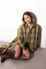 Camisa oversize a rayas celestes y blancas, con cuello camisero, manga larga y hilera de botones dorados metálicos.