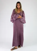 Vestido largo de algodón color lila, con escote en V y mangas largas amplias con volados escalonados.