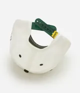 Gorra de béisbol de seis paneles, color blanco con visera curva en contraste de color verde militar. Presenta un bordado frontal de Snoopy junto a un banderín y el número cinco, y un bordado lateral con el texto 'Peanuts Athletic Department'.