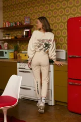 Pantalón de jogging color crema con logo de los Rolling Stones en rojo en la pierna.