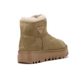 Pantubota de cuero gamuzado color kaki, con interior forrado en lana natural y suela de plataforma dentada en tono a juego. Presenta un aplique triangular con el logo de la marca en el lateral.