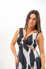 Vestido largo de satén con estampado abstracto en blanco y negro, escote en V, aberturas cut-out en la cintura y aberturas laterales en la falda.