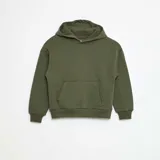 Buzo de corte holgado en color verde, confeccionado en tejido de algodón, con capucha integrada y bolsillo frontal tipo canguro. Presenta puños y ruedo acanalados.