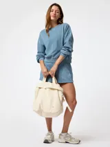Buzo oversize color celeste de cuello redondo, con mangas largas y puños de rib elástico. Presenta un pequeño logo bordado en el pecho.