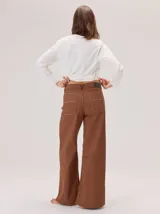 Pantalon de corte ancho y holgado, confeccionado en mezcla de algodón, viscosa y lino. Presenta costuras decorativas, pinzas debajo de la rodilla, bordado de monograma en el bolsillo delantero y pespuntes a contratono.