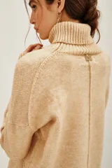 Polera de cuello alto en color beige, confeccionada en tejido de punto suave. Presenta un diseño clásico de manga larga con puños acanalados.