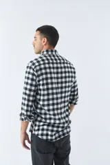 Camisa de viyela a cuadros negros, blancos y rojos, de corte slim fit, con bolsillos en el pecho, manga larga y cierre con botones.