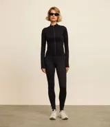 Campera deportiva de corte ajustado, confeccionada en tejido seamless de poliamida y elastano. Presenta cuello alto, cierre frontal con cremallera y textura acanalada.