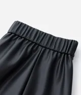 Falda midi de corte evasé confeccionada en cuero sintético (PU) de color negro. Presenta cintura estructurada con pasacintos y diseño de paneles verticales que aportan fluidez a la prenda.