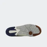 Championes New Balance 550 color blanco con detalles en marrón y azul.