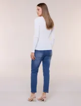 Blusa de punto acanalado fino, color negro, con ajuste al cuerpo, escote a la base y mangas largas. Cuenta con apliques de strass dispuestos en líneas verticales paralelas en el frente y las mangas, además de una vista decorada con estrás brillantes en el escote.