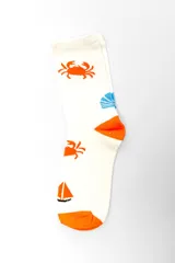 Pack de tres pares de medias estilo crew con diseños variados: un par liso en color tostado, un par beige con rayas horizontales en tonos terracota y blanco, y un par blanco con estampado de cangrejos y veleros naranjas.