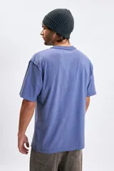 Remera de manga corta con corte oversize, color azul piedra, con cuello redondo y estampa minimalista en el pecho con el texto 'The Rocky Mountains'.