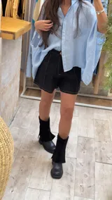 Short de lino en color celeste, con diseño de tiro alto, cierre frontal con botón a la vista y costuras decorativas verticales en el frente.