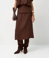 Pollera midi de viscosa color marrón, con diseño de canesú estructurado en la cintura que aporta una división visual y un ajuste definido.