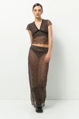 Top de encaje negro con escote en V y tiras de terciopelo. Es de manga corta y corte ajustado.