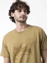 Remera color tostado con estampa frontal de montañas y mapas topográficos, manga corta y cuello redondo.