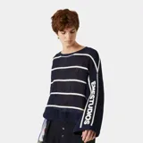 Suéter de punto calado con perforaciones transpirables, de color azul marino con rayas horizontales blancas. Tiene diseño holgado, cuello redondo y mangas amplias con hombros caídos que incluyen el logo de la marca tejido en la manga.