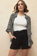 Short negro de tiro alto con cinturón incluido, de tela liviana y bolsillos laterales.