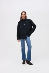 Sobrecamisa de algodón en color negro, con cuello solapa, cierre frontal de botones personalizados y dos bolsillos frontales en el pecho con detalle de bordado de la marca.