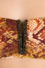 Top bandeau con estampado de piel de serpiente en tonos marrones y dorados, con detalle bordado en el centro del escote.