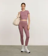 Remera deportiva tipo crop top de color negro, con cuello redondo y mangas cortas. Confeccionada en tejido de malla suave y elástico.