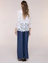 Chaqueta de encaje calado blanco, con escote en V, frente abierto y mangas 3/4 acampanadas con terminación festonada.