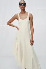 Vestido largo color blanco de algodón, con escote redondo, tirantes anchos y bajo asimétrico con godets.