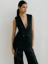 Chaleco sastrero blanco de lino, con cuello en V profundo y cierre cruzado con botones.