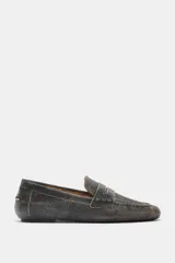 Mocasín plano de piel, color negro con efecto desgastado o envejecido, de punta redonda y con antifaz en el empeine.