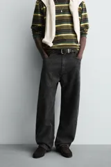 Pantalón de corte baggy fit confeccionado en tejido de algodón con textura y efecto lavado. Presenta diseño de cinco bolsillos, cierre frontal con cremallera y botón.