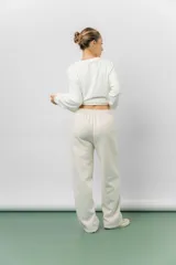 Pantalón deportivo de corte wide leg con caída relajada. Presenta cintura elastizada con cordón ajustable, bolsillos laterales y un interior frizado para mayor abrigo.